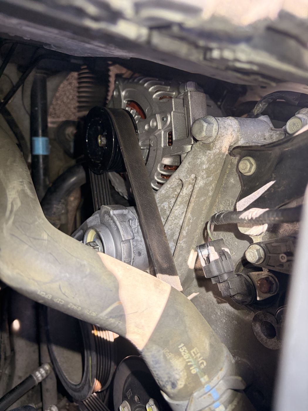 Close-up of the serpentine belt routed over the idler pulley, tensioner and alternator