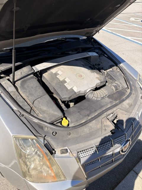 Cadillac CTS V6 engine bay with the hood up in a parking lot