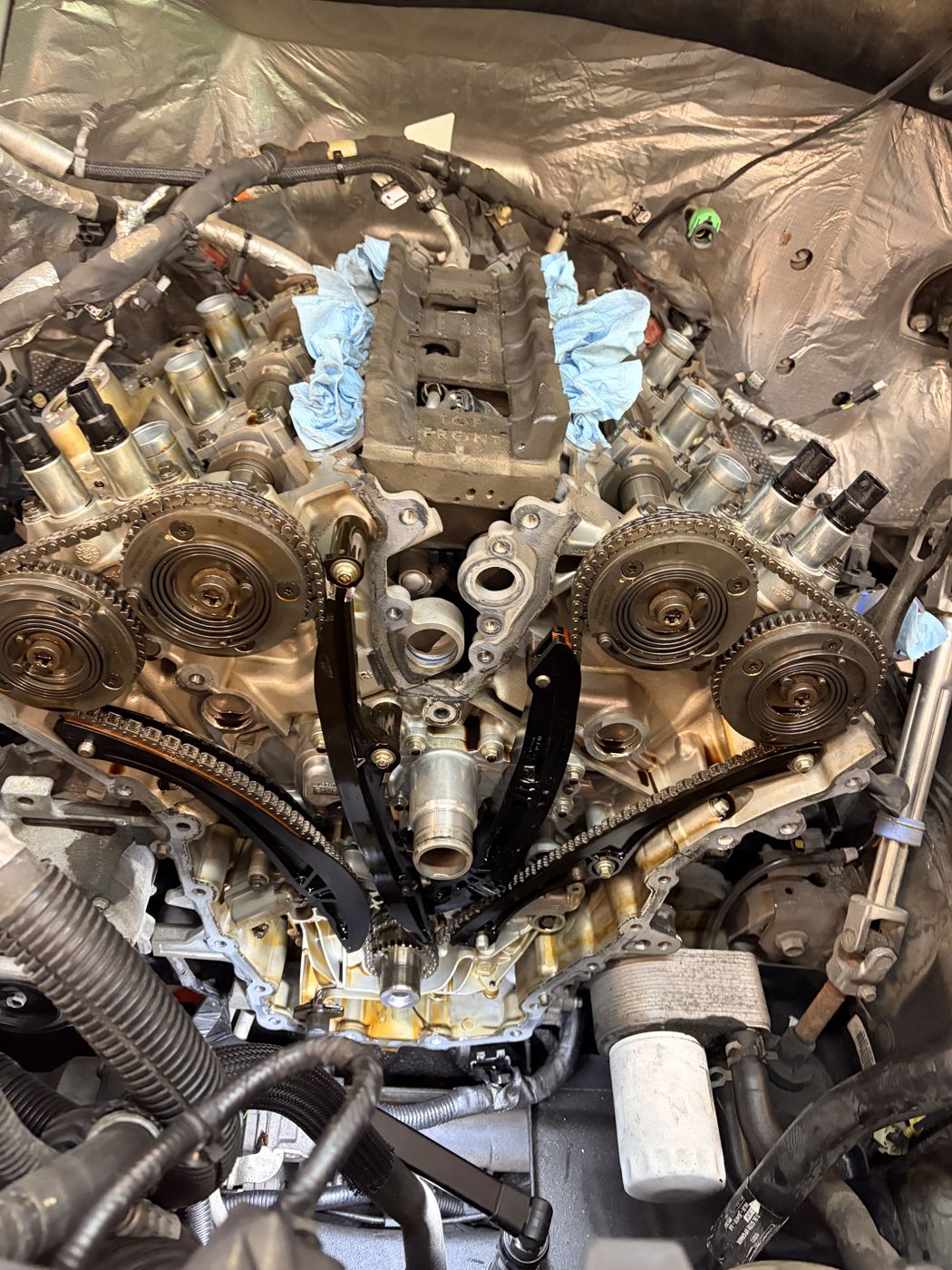 V6 engine with the front timing cover off, showing timing chains, guides and cam phasers